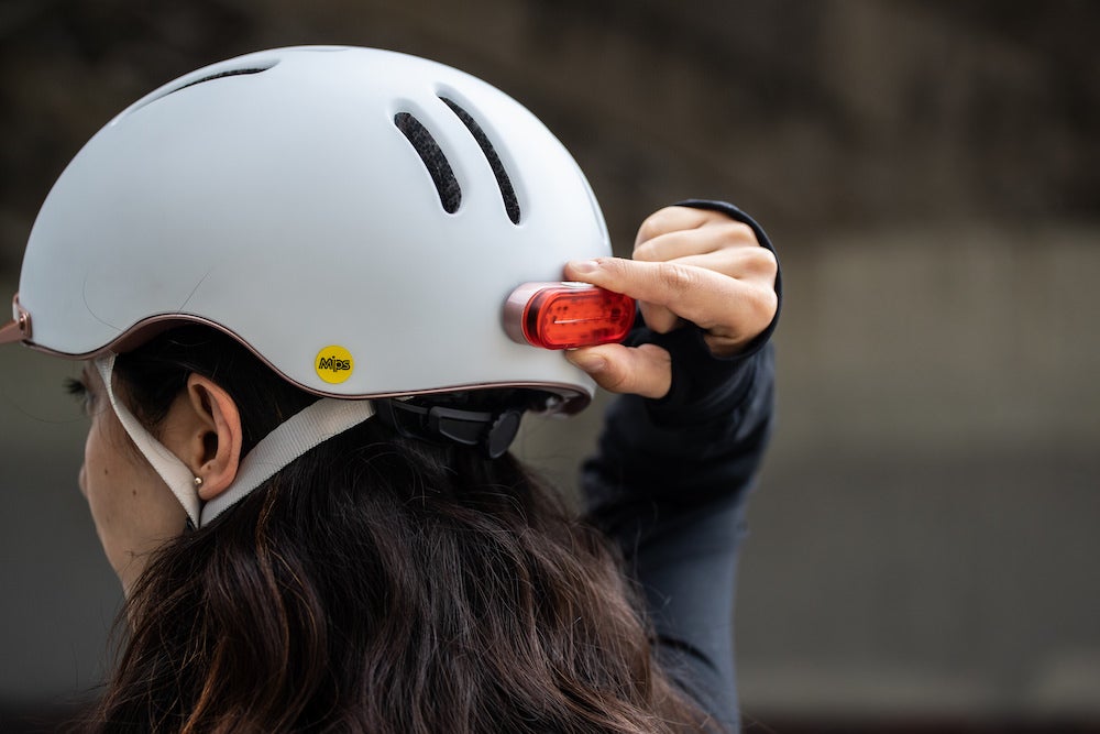 Casque Vélo Thousand Chapter Supermoon Blanc Vue porté par une femme qui allume la lumière