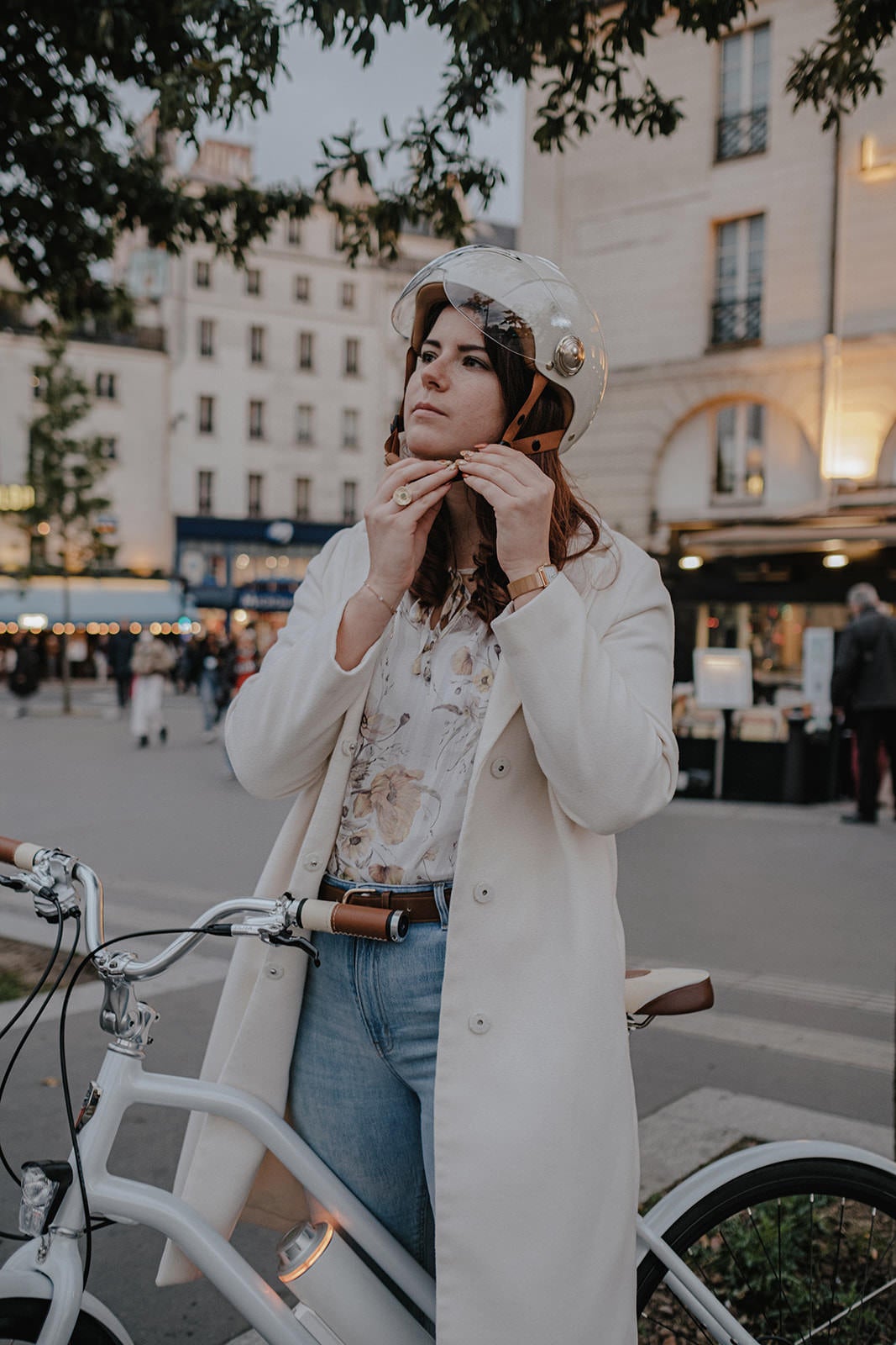 Casque Vélo Urbain Mârkö Helmet Tandem Blanc Ivory porté par une femme qui l'attache