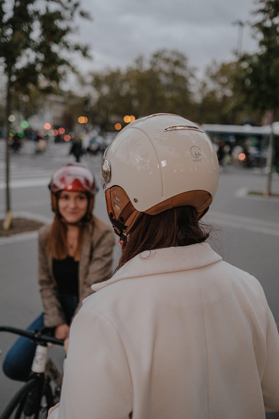 Casque Vélo Urbain Mârkö Helmet Tandem Champagne porté par une femme de dos parlant à une autre femme